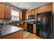 Efficient kitchen with wooden cabinetry, black appliances, and plenty of counter space at 8938 Planters Row Ln, Summerville, SC 29485