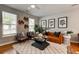 Spacious and decorated living room with a textured rug, plants, and stylish artwork at 8938 Planters Row Ln, Summerville, SC 29485