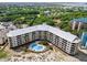 Stunning aerial view of the condo building, pool and lush green surroundings with beach access and partial ocean views at 9002 Palmetto Dr # 420, Isle of Palms, SC 29451
