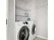 Efficient laundry room with modern washer and dryer, complemented by shelving for ample storage at 9002 Palmetto Dr # 420, Isle of Palms, SC 29451