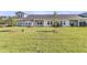 Exterior view of the backyard area with green grass and other homes in the background at 913 Dusk Dr, Summerville, SC 29486