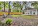 Large backyard with a covered patio, chairs, and mature trees, offering a peaceful retreat for relaxing or entertaining at 920 Simmons Ave, Summerville, SC 29483