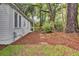 Exterior side view of a house with fresh, white siding, manicured lawn, and stepping stones leading around the house at 920 Simmons Ave, Summerville, SC 29483