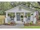 Charming cottage featuring rocking chairs and hanging plants on the welcoming front porch at 920 Simmons Ave, Summerville, SC 29483