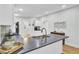 Modern kitchen with white cabinetry, gray backsplash, stainless steel sink, and black countertops at 920 Simmons Ave, Summerville, SC 29483