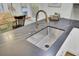 Close up on stainless steel sink, dark countertop and bronze faucet in modern kitchen with gray backsplash at 920 Simmons Ave, Summerville, SC 29483