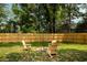 A fire pit and chairs are set up in a backyard with a wooden fence for privacy at St, Charleston, SC 29407