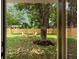 A spacious backyard features a large tree and a seating area with a wooden fence at St, Charleston, SC 29407
