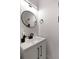 Elegant half-bathroom features a modern vanity with a round mirror and a stylish faucet at St, Charleston, SC 29407