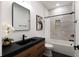 Modern bathroom with a sleek vanity, decorative mirror, and tiled shower/tub combination at St, Charleston, SC 29407