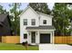 Charming two-story home features a modern design with a black garage door and a well-maintained front yard at St, Charleston, SC 29407