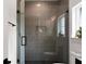 Close up of a tiled shower with glass doors and a black showerhead at St, Charleston, SC 29407