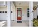 Red front door is framed by white columns and a small porch with tasteful decor at 106 Sago Ct, Summerville, SC 29486