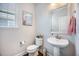 Cozy half bathroom with a pedestal sink, toilet, and decorative art at 106 Sago Ct, Summerville, SC 29486