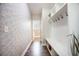 Hallway with geometric wallpaper, hardwood floors, and a built-in storage bench with hooks at 106 Sago Ct, Summerville, SC 29486