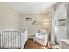 Well-lit Bedroom with a crib, a cozy armchair, and ample space for play at 1107 S Shadow Dr, Mount Pleasant, SC 29464
