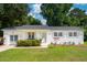 Charming white brick home featuring shutters, manicured lawn and mature trees at 1107 S Shadow Dr, Mount Pleasant, SC 29464