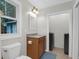 Bright bathroom with a wooden vanity, white toilet, neutral wall paint, and nearby modern washer and dryer at 112 Fox Chase Dr, Goose Creek, SC 29445