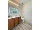 A full bathroom with wood cabinets, a sink, a lighted mirror, a toilet, and neutral flooring at 1225 Blakeway St # 906, Charleston, SC 29492