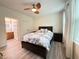 A bedroom featuring a dark wood bed, neutral walls, and a window with white curtains and adjacent bathroom at 1225 Blakeway St # 906, Charleston, SC 29492