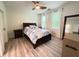This bedroom features a dark wood bed, neutral walls, and a window with white curtains at 1225 Blakeway St # 906, Charleston, SC 29492