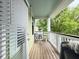 Outdoor patio with wood flooring, white railings, and green views through the trees at 1225 Blakeway St # 906, Charleston, SC 29492