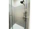 A gray tiled shower with a handheld shower head and glass door at 1225 Blakeway St # 906, Charleston, SC 29492