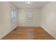 Empty bedroom with hardwood floors, two windows, and white trim at 1248 Sumner Ave, North Charleston, SC 29406