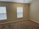 Bright, airy bedroom has two windows for natural light and neutral carpeting at 126 Woodward Rd, Goose Creek, SC 29445