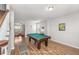 Game room with pool table adjacent to living room features an open layout and wood-look flooring at 1301 Wild Goose Trl, Summerville, SC 29483