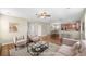 Open-concept living room boasts hardwood floors, neutral paint, and ceiling fan connecting kitchen and dining areas at 1301 Wild Goose Trl, Summerville, SC 29483