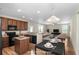 Open-concept kitchen and living room boasts wood cabinets, breakfast bar, dining area, and inviting furniture at 1301 Wild Goose Trl, Summerville, SC 29483