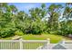 A large backyard with a white railing, grassy area, and some trees with blue sky above at 142 Maxwell Rd, Summerville, SC 29483