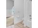 An all-white bathroom features a toilet and partially-visible shower and bedroom beyond at 142 Maxwell Rd, Summerville, SC 29483