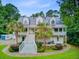 Stunning two-story home featuring double porches, a metal roof, and lush landscaping, creating curb appeal at 142 Maxwell Rd, Summerville, SC 29483