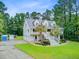 Charming two-story home with a metal roof, double porches, mature trees, and lush landscaping at 142 Maxwell Rd, Summerville, SC 29483