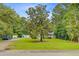 Beautiful home with a metal roof, double porches, mature trees, and an expansive green lawn and driveway at 142 Maxwell Rd, Summerville, SC 29483
