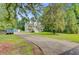 Inviting home showcasing mature trees, a metal roof, double porches, and a long private driveway at 142 Maxwell Rd, Summerville, SC 29483