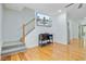 Bright living room featuring hardwood floors, staircase, and a large television with a palm tree fountain at 142 Maxwell Rd, Summerville, SC 29483