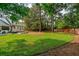 Lush backyard with green lawn, mature trees, patio area and trampoline, perfect for outdoor living at 1446 Burningtree Rd, Charleston, SC 29412