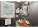 Elegant powder room featuring a unique wood countertop, decorative mirror, and stylish wall sconce at 1446 Burningtree Rd, Charleston, SC 29412