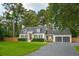 Charming two-story home featuring a manicured lawn, gray shutters, a well maintained roof, and a gravel driveway at 1446 Burningtree Rd, Charleston, SC 29412