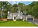 Charming home with a manicured lawn, dark shutters, and a brick paver driveway leading to the attached garage at 1446 Burningtree Rd, Charleston, SC 29412