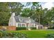 Charming home boasts mature trees, a manicured lawn, dark shutters, and an attached two-car garage at 1446 Burningtree Rd, Charleston, SC 29412
