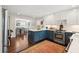 Bright kitchen featuring white cabinets, blue island, stainless steel appliances, and a view to the dining area at 1446 Burningtree Rd, Charleston, SC 29412