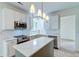 Well-lit kitchen features modern cabinetry, an island with seating, stainless steel appliances, and stone countertops at 1552 Harborsun Dr, Charleston, SC 29412