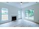 Cozy living room with a decorative fireplace, large windows, ceiling fan, and hardwood floors at 1552 Harborsun Dr, Charleston, SC 29412