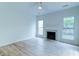 Cozy living room with a decorative fireplace, large windows, ceiling fan, and hardwood floors at 1552 Harborsun Dr, Charleston, SC 29412