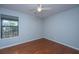 This bedroom offers a window overlooking the yard, hardwood floors and a modern ceiling fan at 1686 Hunters Run Dr, Mount Pleasant, SC 29464