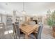 Open dining area with wood table, grey upholstered chairs, and a modern chandelier at 1800 Palmetto Isle Dr, Mount Pleasant, SC 29466